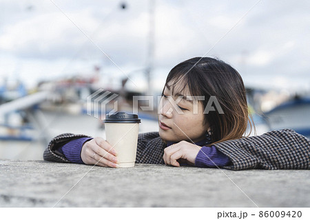 コーヒーをテイクアウトする女性 86009420