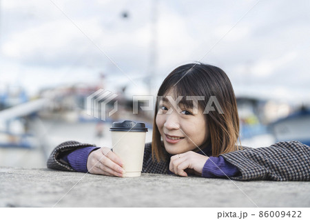 コーヒーをテイクアウトする女性 86009422
