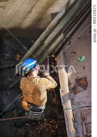 解体建設工事現場でのガスバーナーによる切断・溶接作業を行う男性作業員 86010871