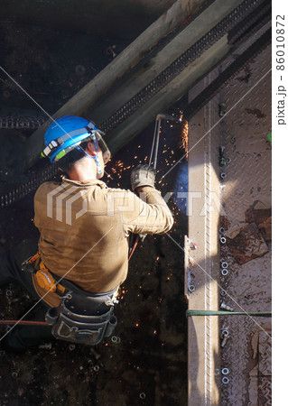 解体建設工事現場でのガスバーナーによる切断・溶接作業を行う男性作業員 86010872