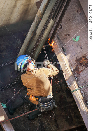 解体建設工事現場でのガスバーナーによる切断・溶接作業を行う男性作業員 86010873
