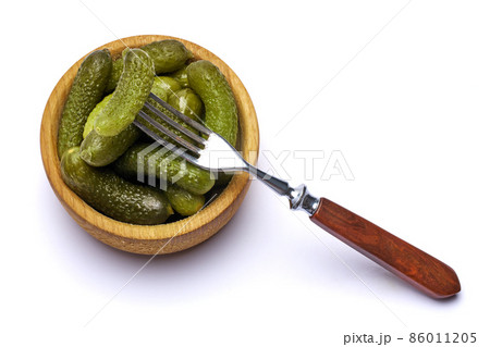 Bowl of Tasty canned Whole green cornichons isolated on a white background 86011205