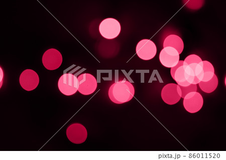 Defocused bokeh lights on black background, an abstract naturally blurred backdrop for Valentine's Day or birthday party. Festive light texture. Pink and red garland in blur. Overlay effect for design Defocused bokeh lights on black background, an abstract naturally blurred backdrop for Valentine's Day or birthday party. Festive light texture. Pink and red garland in blur. Overlay effect for design 86011520
