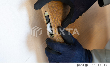 扉(スライドドア)の戸車を修理・点検する作業員 86014015