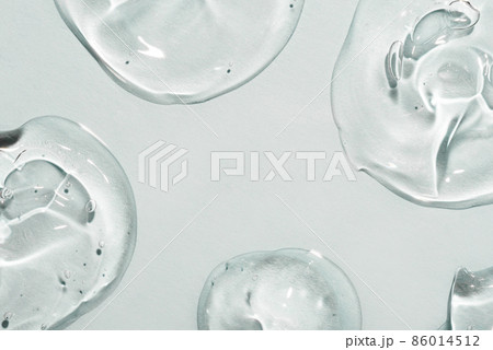 Transparent hyaluronic acid gel drops on a gray background. Transparent hyaluronic acid gel drops on a gray background. 86014512