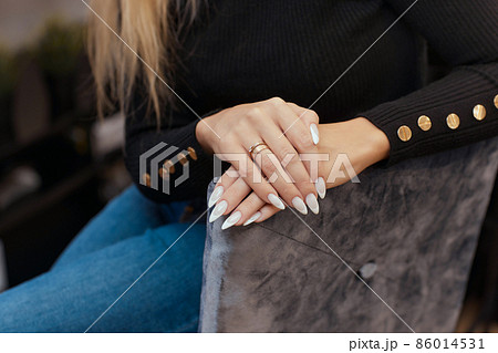Beautiful manicure. Nail polish being applied to hand, polish is a blue color. Blue background closeup. Beautiful manicure. Nail polish being applied to hand, polish is a blue color. Blue background closeup. 86014531