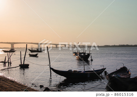 Silhouettes of moored fishing boats in the sunset outside Hoi an, Vietnam Silhouettes of moored fishing boats in the sunset outside Hoi an, Vietnam 86015316