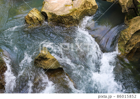 Clear water flowing through the rocks 86015852