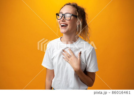 Cheerful smiling young girl against yellow background 86016461