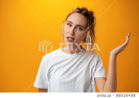 Young beautiful woman thinking looking to the side against yellow background Young beautiful woman thinking looking to the side against yellow background 86016488