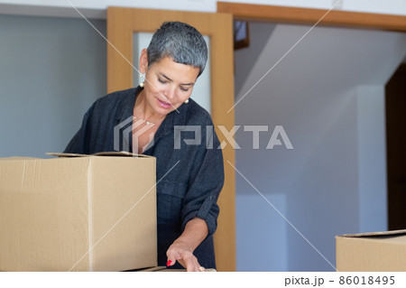 Concentrated mid adult woman moving into new apartment 86018495