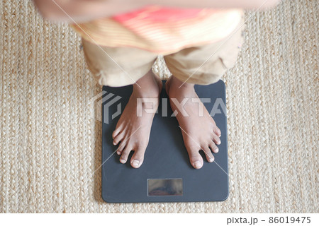 man's feet on weight scale close up. 86019475