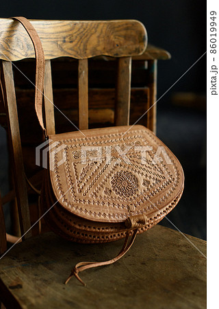 small brown women's leather bag with a carved pattern. selective focus small brown women's leather bag with a carved pattern. selective focus 86019949