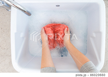 Female hands washing color clothes in sink 86020660