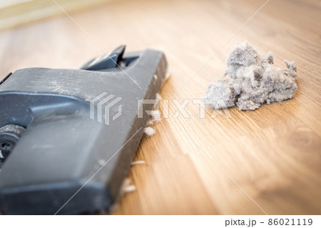 Dust and dirt on a wooden floor with vacuum cleaner 86021119