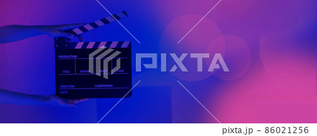 Blurry images of movie slate or clapper board. Hand holds empty film making clapperboard on color background in studio for film movie shooting or recording. Film slate for Youtuber video production. 86021256