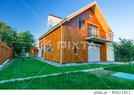Wooden house with meadow in front of it Wooden house with meadow in front of it 86021851