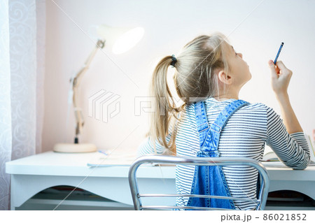 Teenage girl doing homework at table at home preparing for school test Teenage girl doing homework at table at home preparing for school test 86021852