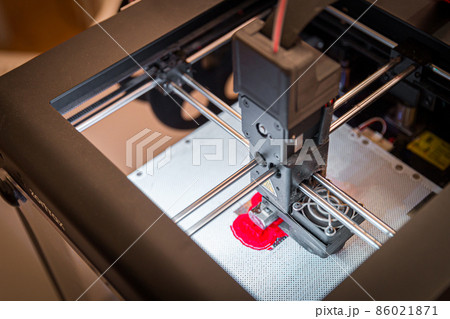 Modern 3D printer printing small red figure, closeup view from above 86021871