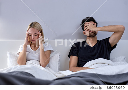 Angry couple having arguments and sexual problems in bed. Portrait of unhappy couple Angry couple having arguments and sexual problems in bed. Portrait of unhappy couple 86023060