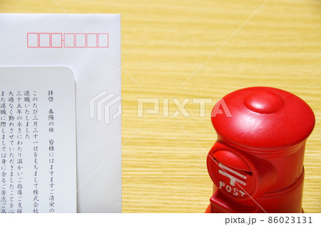 木目のテーブルに置いた郵便ポスト形の貯金箱と礼文の封筒 木目のテーブルに置いた郵便ポスト形の貯金箱と礼文の封筒 86023131