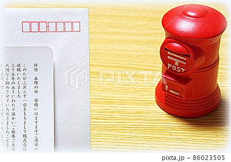 【イラスト風】木目の机に置いた郵便ポスト形の貯金箱と礼文の封筒 86023505