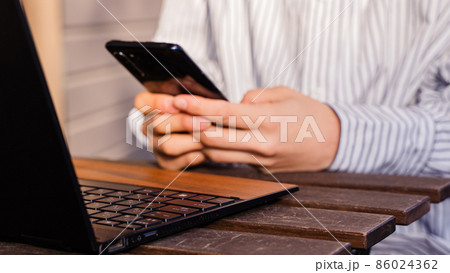 ビジネス用 パソコン作業しながらスマホを打つ女性 ビジネス用 パソコン作業しながらスマホを打つ女性 86024362