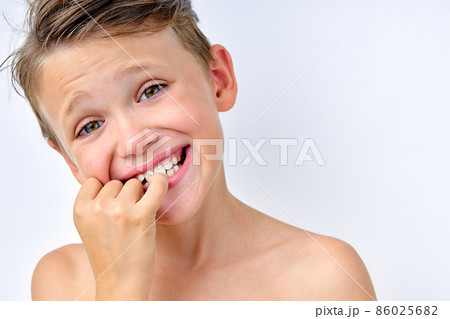 child boy touching teeth, checking the cleanliness, looking at mirror. isolated on white child boy touching teeth, checking the cleanliness, looking at mirror. isolated on white 86025682
