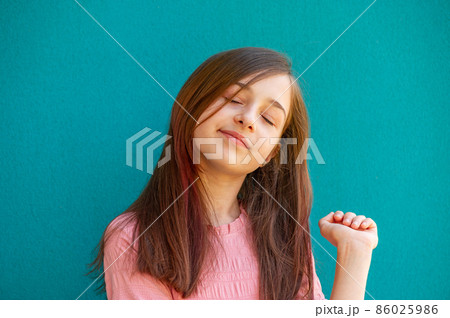 Girl in a pink dress on a turquoise background. 86025986
