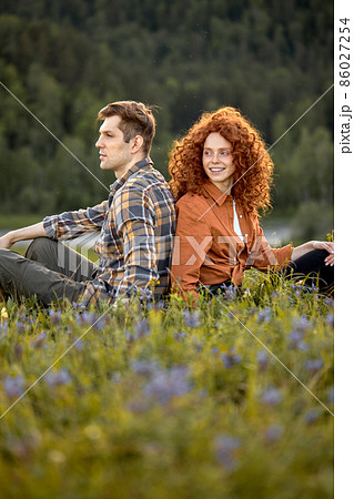 Young Caucasian Attractive Young Couple Sitting On Grass Together Relaxing 86027254