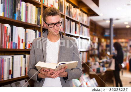 Smiling guy reading interesting books 86028227