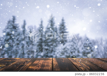 Winter forest with wooden table background. Blurred snow landscape and empty rustic table for product or merchandise. 86032236