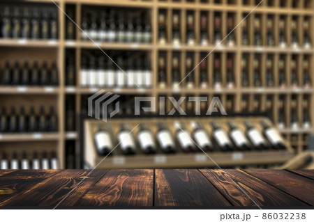 Wine wooden table background. Blurred wine shop with bottles on the counter. 86032238