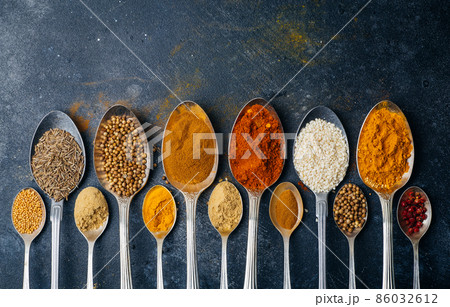 Spices in spoons background. Varieties of spices turmeric, pepper, chili, coriander, cinnamon and peppers for cooking. Culinary food concept. 86032612