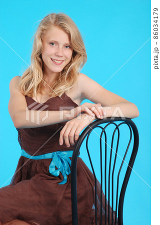Smiling girl sits on a chair isolated Smiling girl sits on a chair isolated 86034179