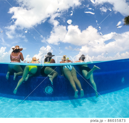 Half underwater split image of young women having fun in hotel pool in Caribbean sea. Concept of vacation and bachelorette pool party 86035873