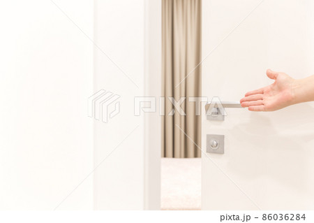 Woman's hand opening door in bedroom 86036284