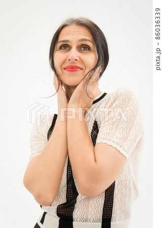 Studio photo of middle aged woman starting getting grey-haired wearing black and white clothes on white background, middle age sexy lady, happy life concept 86036339
