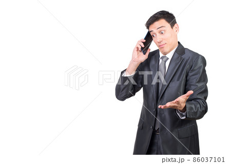 Confused man in suit talking on smartphone 86037101