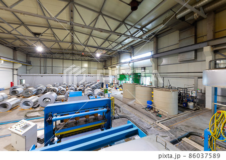 Production line of metal tile for roof. Steel forming machine in metalwork factory workshop. Metal Production line of metal tile for roof. Steel forming machine in metalwork factory workshop. Metal 86037589