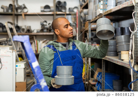 Hispanic foreman looking for construction supplies in building hypermarket Hispanic foreman looking for construction supplies in building hypermarket 86038125