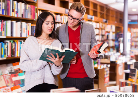 Adult handsome man and girl choosing books Adult handsome man and girl choosing books 86038658