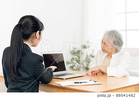 打ち合わせするスーツ姿の女性と高齢者女性 打ち合わせするスーツ姿の女性と高齢者女性 86041482