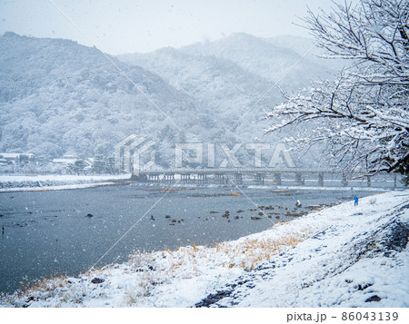 雪降る嵐山の渡月橋 86043139