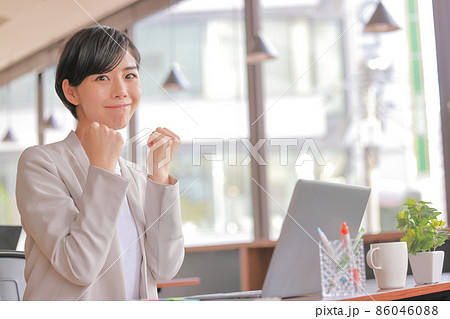 両手でガッツポーズ 気合を入れて仕事を始めるビジネスウーマン1の写真素材