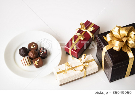 金リボンのプレゼントボックスとチョコレート 金リボンのプレゼントボックスとチョコレート 86049060