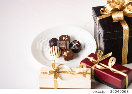 金リボンのプレゼントボックスとチョコレート 金リボンのプレゼントボックスとチョコレート 86049068