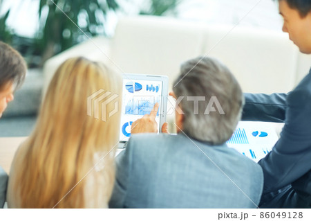 Image of business partners discussing financial schedule for the meeting Image of business partners discussing financial schedule for the meeting 86049128
