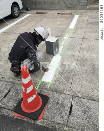 駐車場の区画ラインをローラー塗装で塗り替える男性塗装職人2 86052168