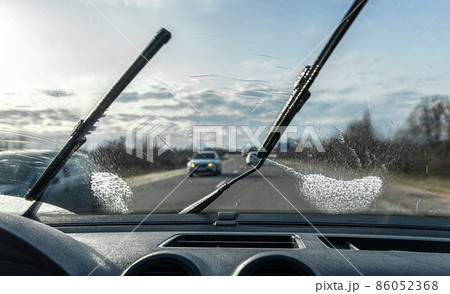 Car wipers clean windshields when driving in sunny weather. 86052368